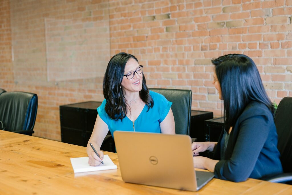 Professionals discussing financial information at a laptop